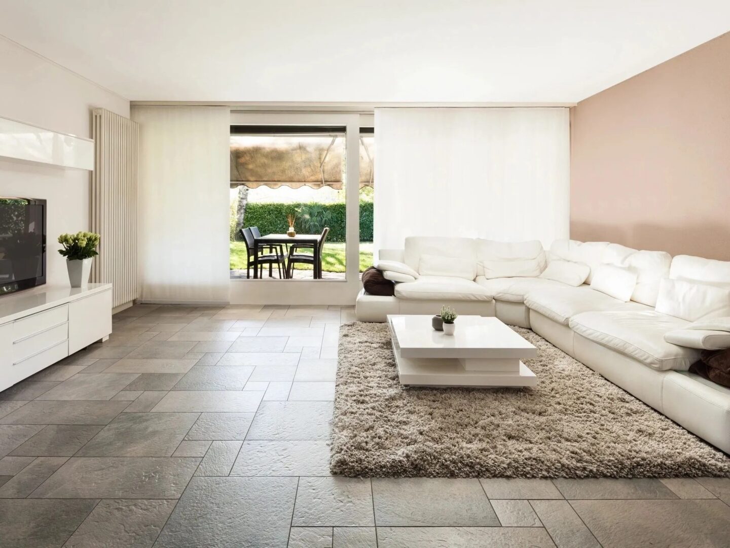 A living room with white furniture and tile floors.