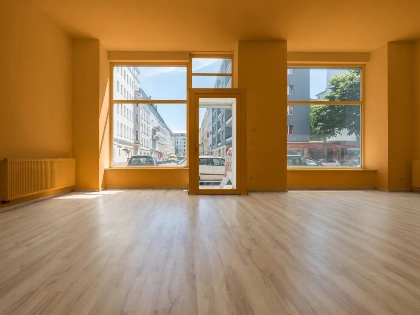 A room with wooden floors and large windows.