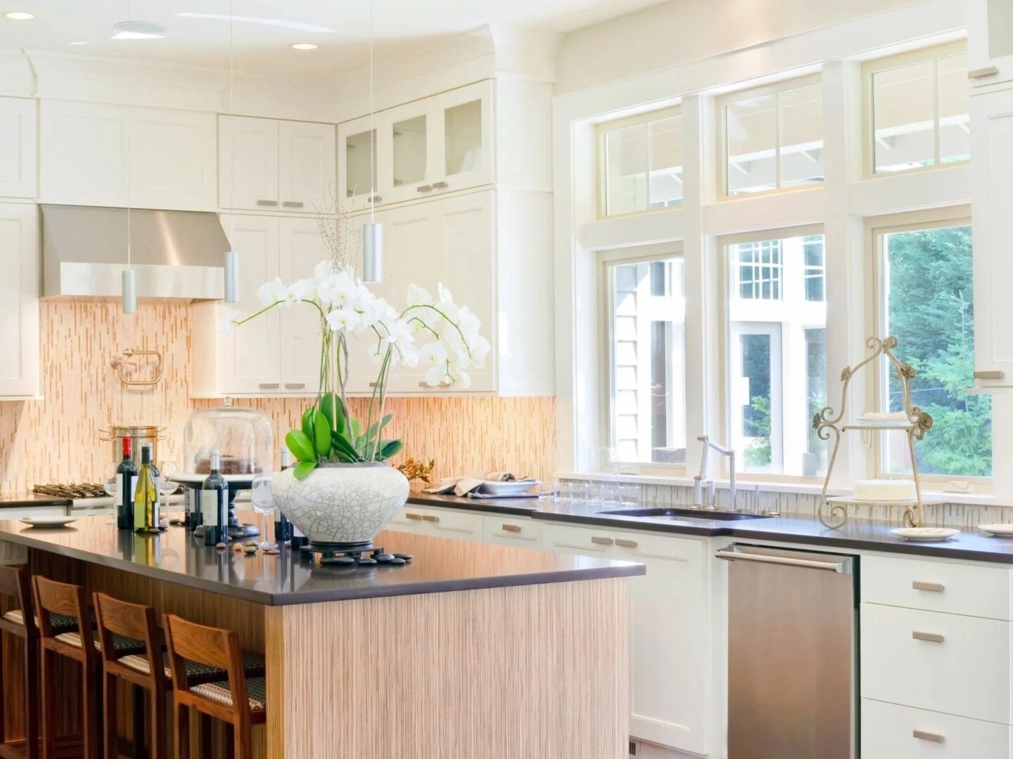A kitchen with white cabinets and black counter tops.
