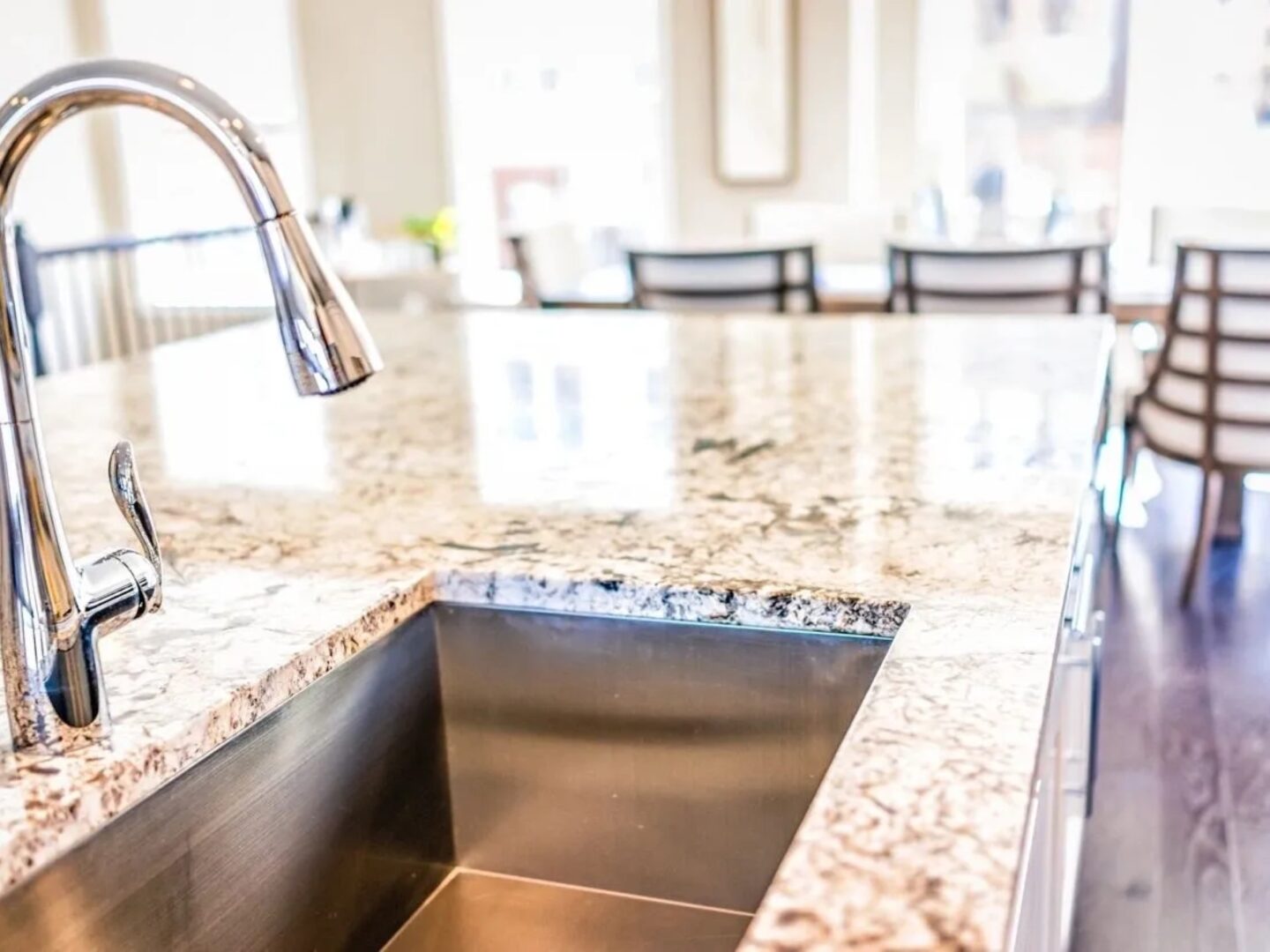 A kitchen sink with a granite counter top.